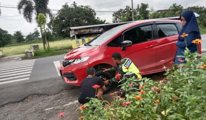 Babinsa 03/Tembelang Serda Lutfi Turun Tangan Membantu Penguna jalan Yang Mengalami Pecah Ban